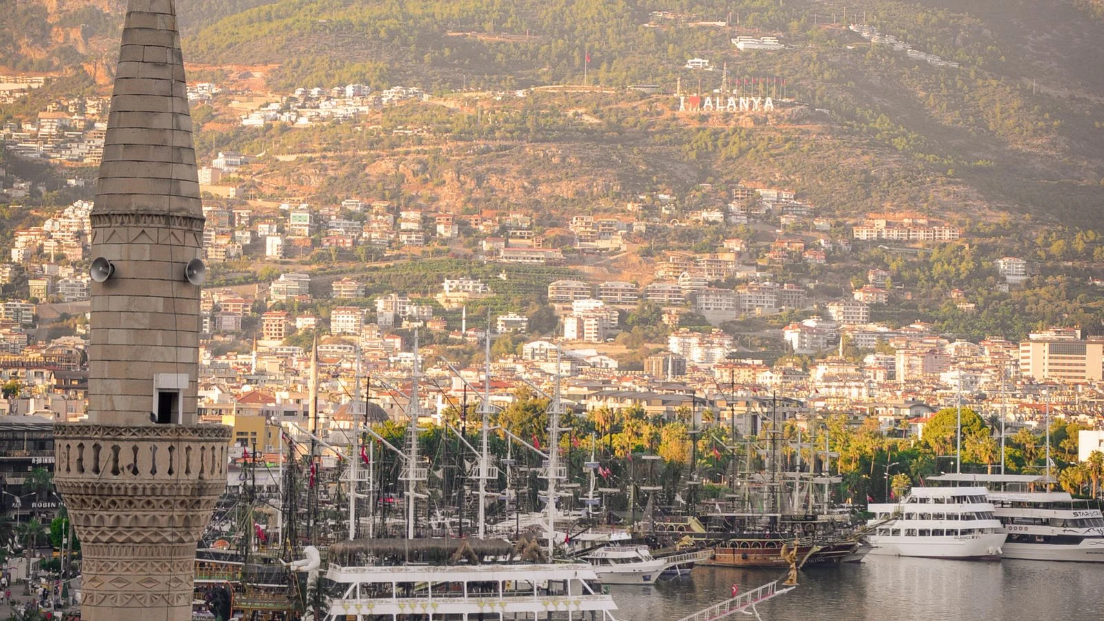 Sailboats in Alanya harbour with mountains at sunset
