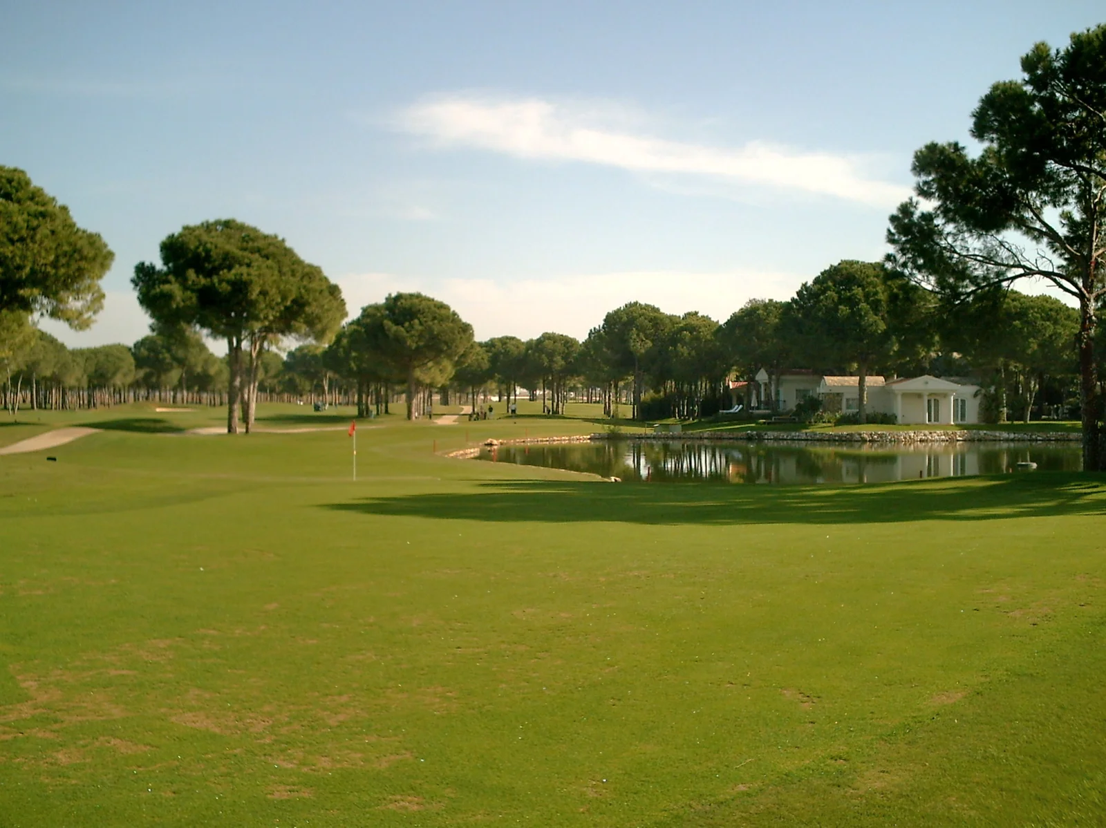 Nobilis golf course in Belek with pine trees and a water hazard