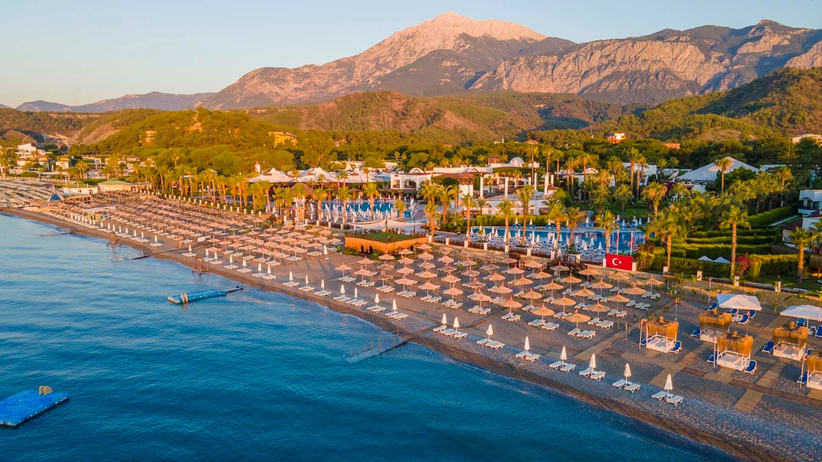 Aerial view of Çamyuva Beach resorts beneath the Taurus Mountains
