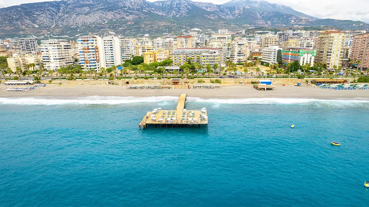 Mahmutlar coast with Grand Santana beach pier, apartment skyline and Taurus Mountains
