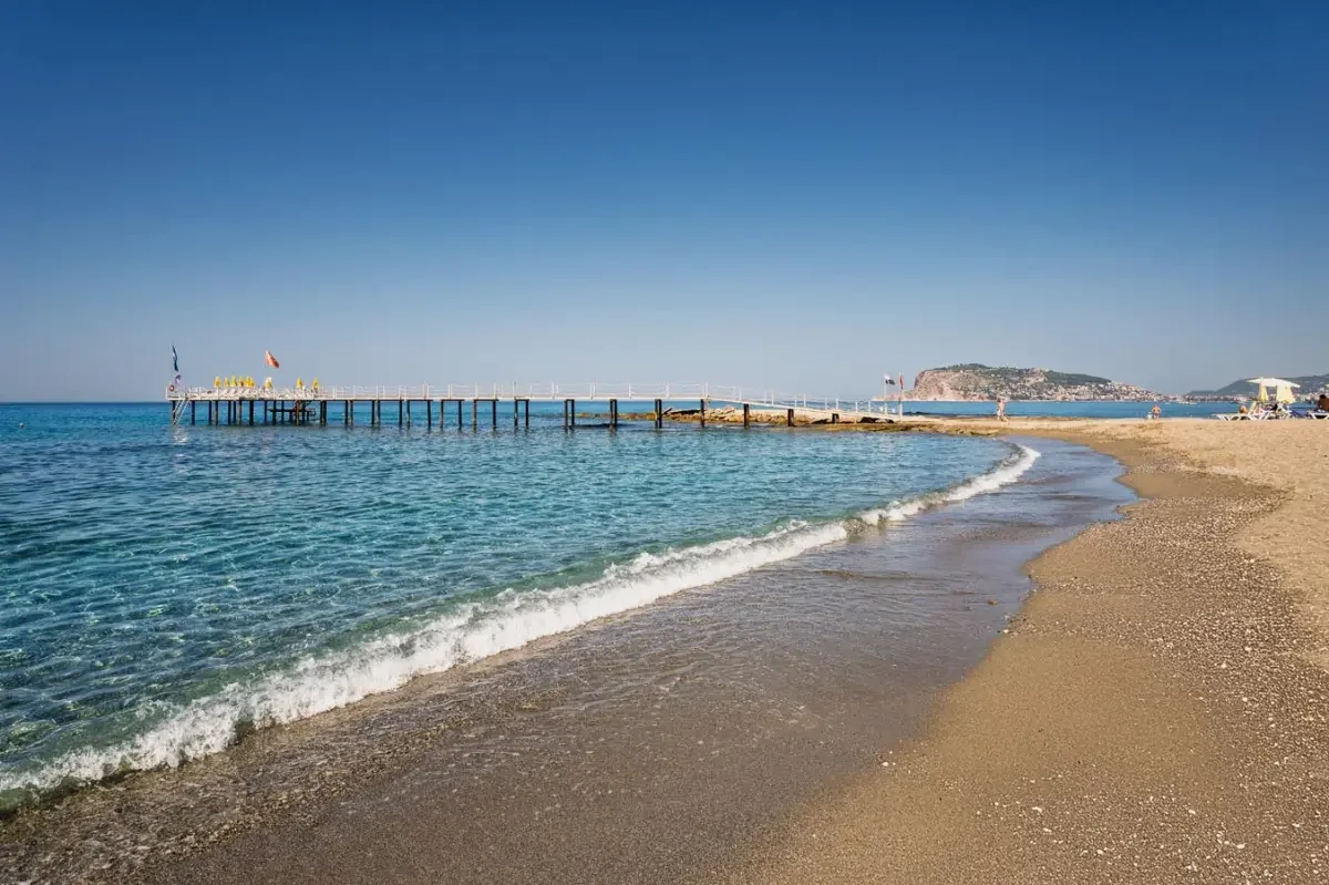 Tosmur’s sand-and-pebble beach with the Alanya peninsula in the distance